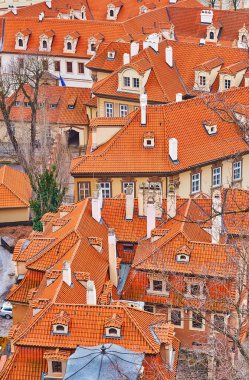 Mala Strana 'nın (Küçük Mahalle) eski kırmızı kiremit çatıları, Çek Cumhuriyeti' nin Prag kentindeki Castle Hill perspektifinden yüksek bacaları olan evler.