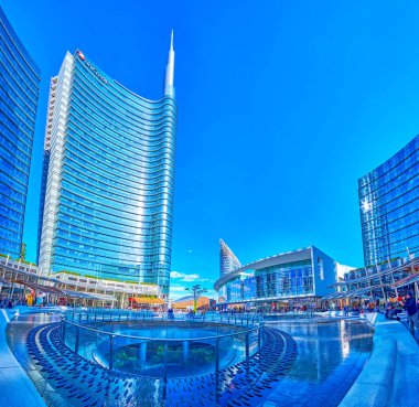 MILAN, İtalya - 9 Nisan 2022: 9 Nisan 'da İtalya' nın Milano kentinde Gae Aulenti meydanında havuz ve cam gökdelenlerle çevrili panorama