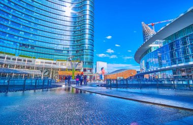 MILAN, ITALY - 9 Nisan 2022: 9 Nisan 'da İtalya' nın Milano kentinde insanlar Piazza Gae Aulenti havuzunda yürüyorlar