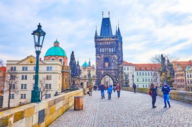 PRAG, CZECH REPUBLIC - 6 Mart 2022: Charles Köprüsü 'ndeki taş Gotik Köprü Kulesi' nin her iki tarafında da 6 Mart 'ta Prag' da güzel taş heykeller bulunuyor.