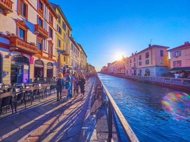 MILAN, İTALYA - 9 Nisan 2022: Naviglio Grande Kanalı 'nın 9 Nisan' da Milano 'daki Navigli Mahallesi' nde bulunan renkli evleriyle gün batımı manzarası