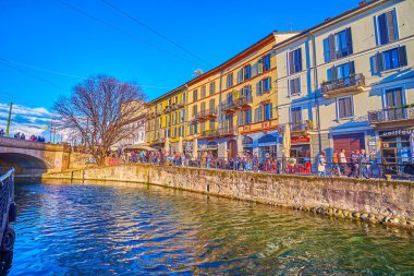 MILAN, İtalya - 9 Nisan 2022: Naviglio Grande Kanalı, 9 Nisan 'da Milano' da turist restoranları, barları ve mağazaları olan renkli evlerle dolu