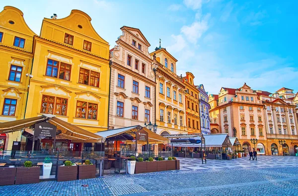 The colored historic facades of townhouses of Old Town Square with outdoor restaurants and bars in the foreground, Stare Mesto, Prague, Czech Republic