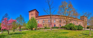 Panorama of Visconti Castle and large park with blooming trees, Pavia, Italy