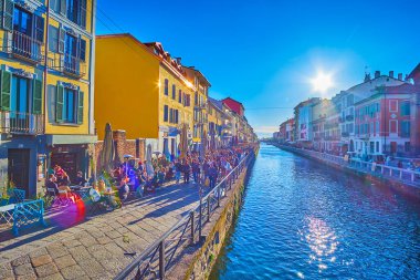 MILAN, ITALY - APRIL 9, 2022: Sunset over Naviglio Grande Canal, the popular spot, bars and stores, on April 9 in Milan