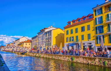MILAN, ITALY - APRIL 9, 2022: Naviglio Grande canal with outdoor restaurants in Navigli old neighborhood, on April 9 in Milan