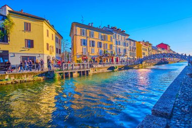 MILAN, ITALY - APRIL 9, 2022: Naviglio Grande Canal with historical houses become one of popular spots of nightlife, on April 9 in Milan, Italy
