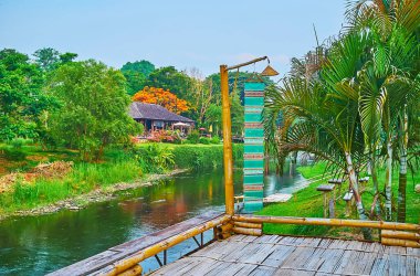 Renkli Lanna bayrağına sahip küçük ahşap teras, Pai nehri ve yeşil kıyıları Pai, Tayland 'ı gözlemleyen bir görüş açısı görevi görüyor.