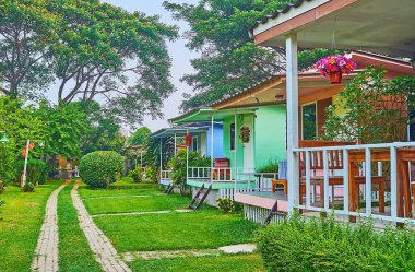 The small colored wooden houses on the lawn on the bank of Pai River, Pai, Thailand
