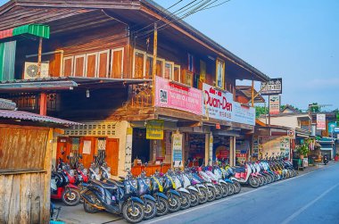 PAI, THAILAND - MAY 6, 2019: The parked taxi bikes on the Walking Street in old town, on May 6 in Pai