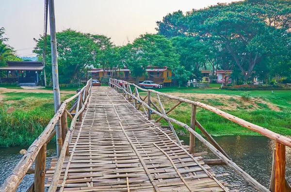 Walk down the shabby bamboo bridge across Pai River, surrounded with lush greenery, Pai, Thailand