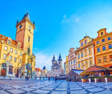 PRAGUE, CZECH REPUBLIC - MARCH 6, 2022: The medieval stone Old Town Square with Old Town Hall, Prague Orloj astronomical clock, townhouses and Tynsky Church in background, on March 6 in Prague