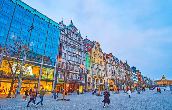 PRAGUE, CZECH REPUBLIC - MARCH 6, 2022: The evening Wenceslas Square with modern and historic buildings, popular stores, cafes, restaurants, on March 6 in Prague