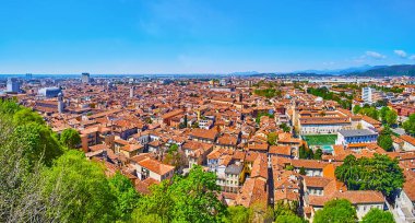 The panoramic skyline of old Brescia with red tile roofs, domes, towers from Cidneo Hill, Lombardy, Italy