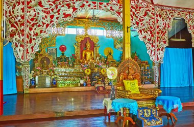 MAE HONG SON, THAILAND - MAY 6, 2019: Interior of colored Viharn in Wat Chong Kham Temple with Buddha image on altar, surrounded with carved and sculptured details, on May 6 in Mae Hong Son