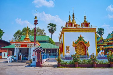 The sculptured gilt Ubosot of Wat Chong Kham Temple with mini-stupas, topped with hti umbrellas, Mae Hong Son, Thailand
