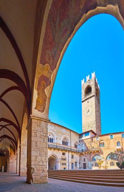 Arcade of Palazzo Broletto, observing the courtyard and Torre del Pegol tower, Brescia, Lombardy, Italy