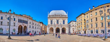 BRESCIA, ITALY - APRIL 10, 2022: Panorama of historic Loggia Square with medieval Palazzo della Loggia, Palazzo Monte di Pieta palace and old houses with outdoor restaurants, on April 10 in Brescia