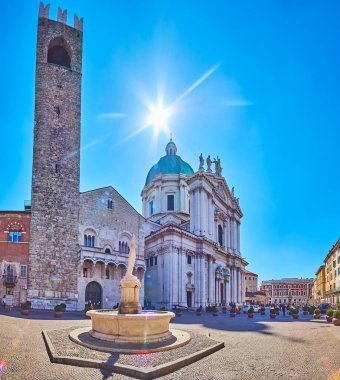 The medieval stone Minerva fountain in front of Broletto Palace and ornate New Cathedral of Brescia, Lombardy, Italy