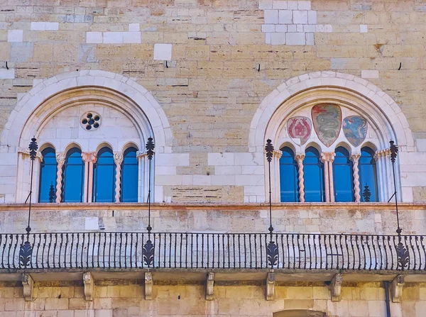 The medieval stone arch windows with solomonic columns and frescoes, Palazzo Broletto, Brescia, Italy