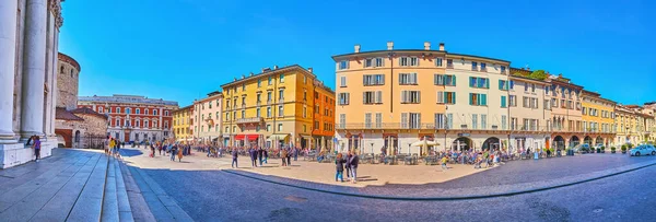BRESCIA, ITALY - APRIL 10, 2022: Panorama of old colored townhouses with line of restaurants and cafes in front of them, Piazza Paolo VI (Piazza del Duomo) square, on April 10 in Brescia