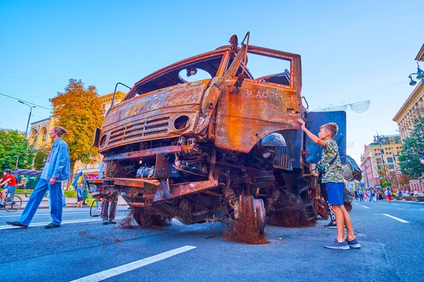 KYIV, UKRAINE - AUGUST 23, 2022: The boy watches the burnt cabin of destroyed Russian Pantsir missile system vehicle, on August 24 in Kyiv, Ukraine