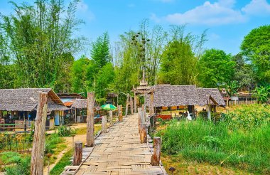 The village wooden huts, surrounded with bamboo thickets and with Su Tong Pae Bamboo Bridge in the foreground, Mae Hong Son suburb, Thailand