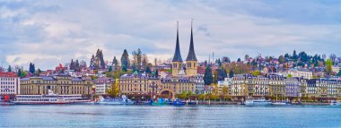 LUCERNE, SWITZERLAND - MARCH 30, 2022: Panorama of Nationalquai embankment with spires of Church of St. Leodegar, on March 30 in  Lucerne, Switzerland
