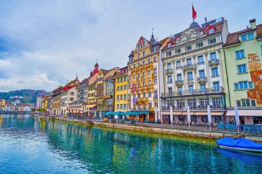LUCERNE, SWITZERLAND - MARCH 30, 2022: Great view on facades of medieval buildings on the embankment of Reuss river in Altstadt district, on March 30 in Lucerne, Switzerland