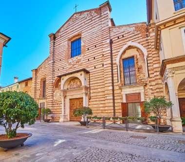 The medieval facade of San Giovanni Evangelista Church with decorative gate with columns and fresco over the doorway, Brescia, Italy