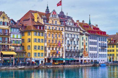 LUCERNE, SWITZERLAND - MARCH 30, 2022: Medieval buildings on Rathausquai embankment of Reuss river, on March 30 in Lucerne, Switzerland