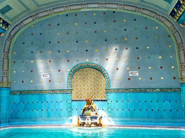 BUDAPEST, HUNGARY - 24 Şubat 2022: 24 Şubat 'ta Budapeşte' de Gellert Spa Hamamları 'nın duvarlarında mozaikler ve fayanslar olan zengin dekore edilmiş termal banyo salonu ve heykel çeşmesi