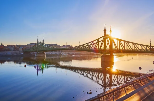 黄金の日の出をお楽しみください 穏やかなドナウ川の表面と華やかなアールヌーボー自由の橋のシルエットに反映 ブダペスト ハンガリー — ストック写真