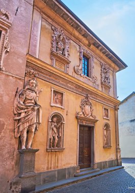 Santa Maria Assunta Kilisesi 'nin çarpıcı ortaçağ cephesi, duvar heykelleri, kabartma süslemeleri ve fresklerle süslenmiş, Locarno, İtalya