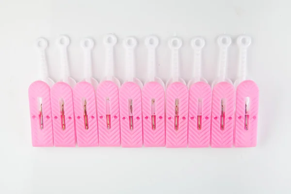 Pink and white clothespins arranged as row with whitel backgroun — Stock Photo, Image