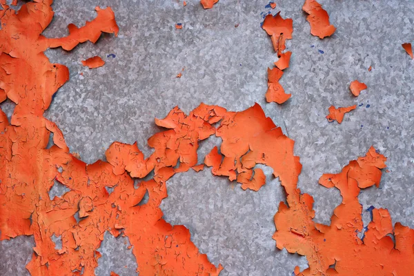 Flaking old orange paint on a stainless steel surface — Stock Photo, Image