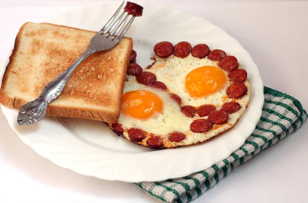Traditional breakfast with eggs and sausages fried — Stock Photo, Image