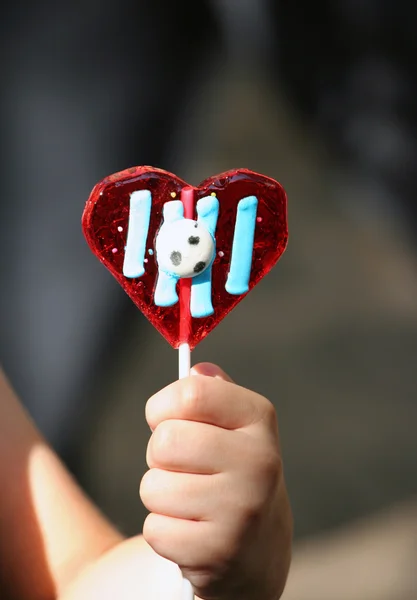 아이의 손에 바르셀로나 하트 모양의 막대 사탕 — 스톡 사진