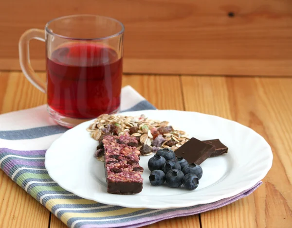 Muesli snack bar, blueberries and berry tea — Stock Photo, Image