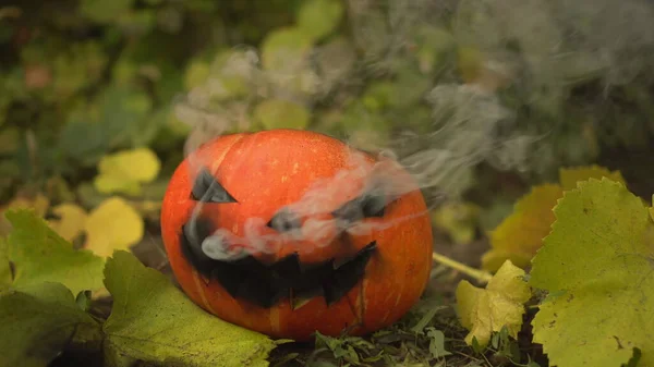 La calabaza de Halloween está fumando. Jack Lantern yace en el suelo en las vacaciones. — Foto de Stock