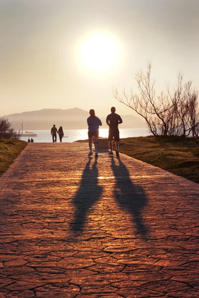Silhouette von Joggen und Wandern im getxo Park bei Sonnenuntergang — Stockfoto