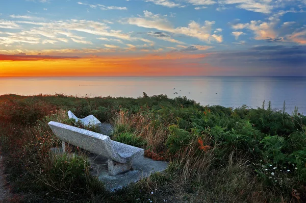 Ein paar Steinbänke mit wunderschönem Blick auf das Meer bei Sonnenuntergang — Stockfoto