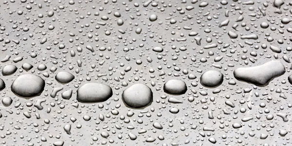 Gotas de lluvia sobre un fondo metálico gris — Foto de Stock