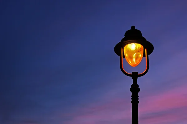 Lamppost illuminated at twilight — Stock Photo, Image