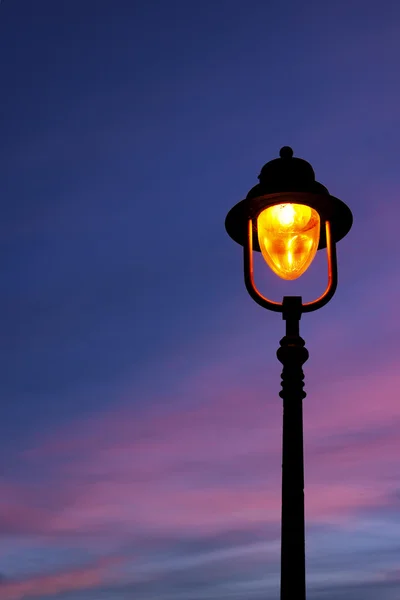 Lantaarnpaal verlicht bij avondschemering — Stockfoto