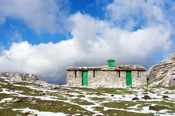 Hütte in den Bergen mit etwas Schnee — Stockfoto