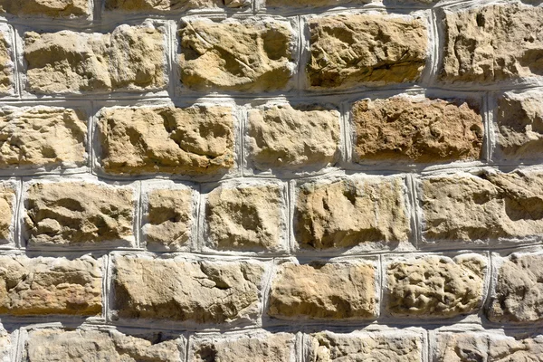 Hintergrund einer Mauer aus strukturierten Steinen — Stockfoto