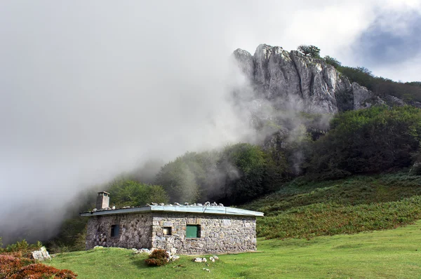 Cabaña de piedra en la montaña con niebla —  Fotos de Stock