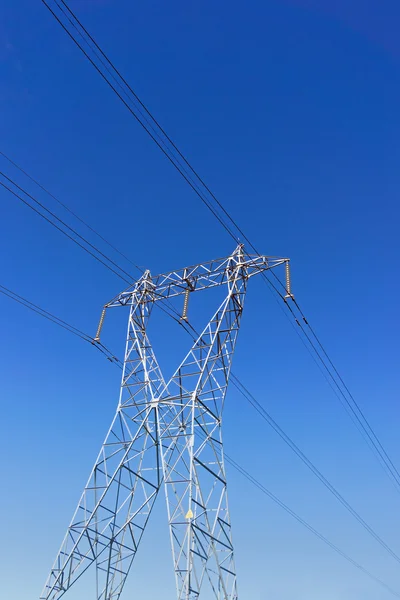 Högspänning överföring torn mot blå himmel — Stockfoto