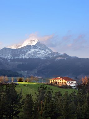 typical basque country house surrounding by mountains clipart